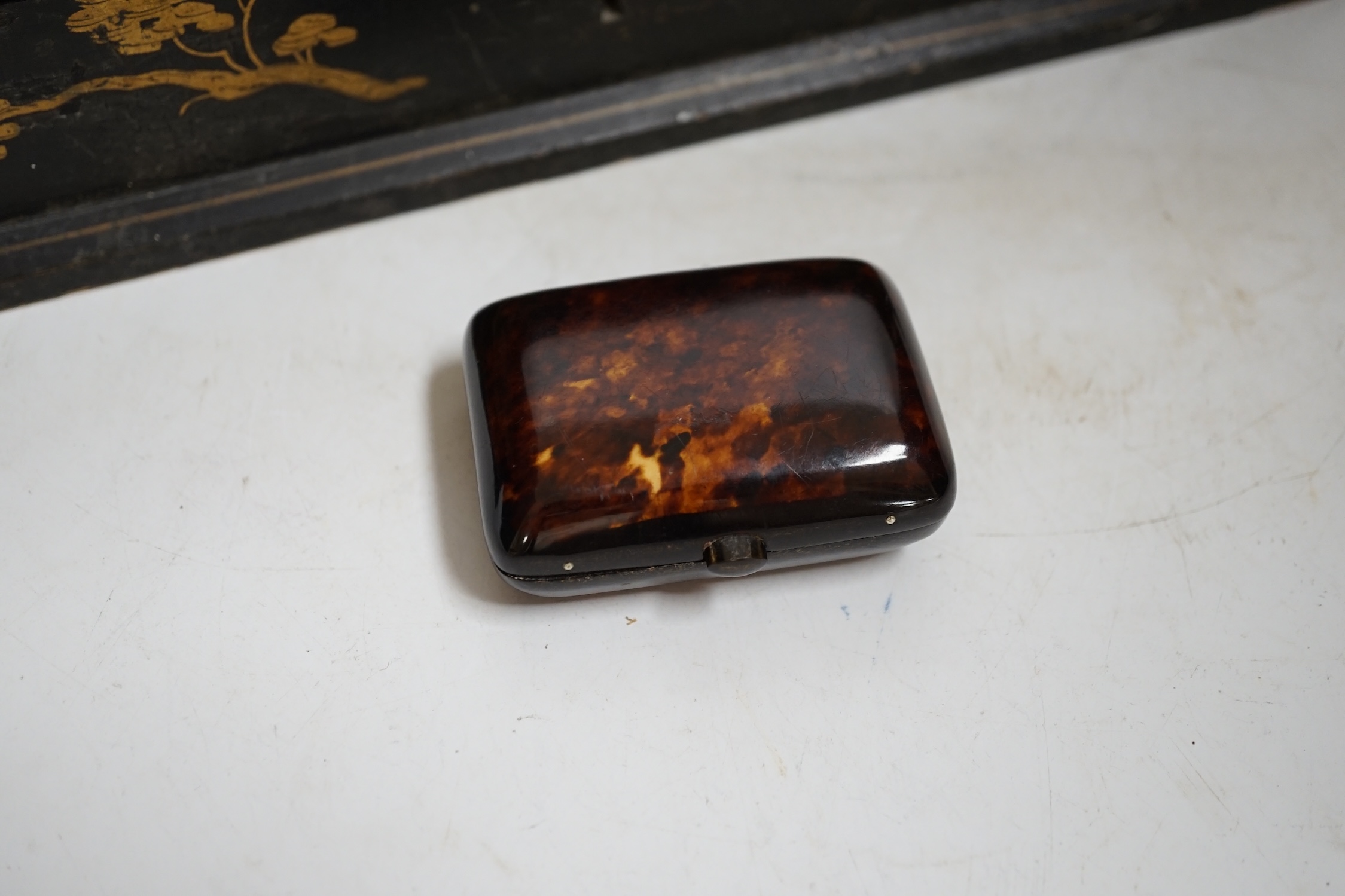 A French japanned papier maché glove box together with a tortoiseshell card case inlaid with white and yellow metal, largest 30cm wide. Condition- fair